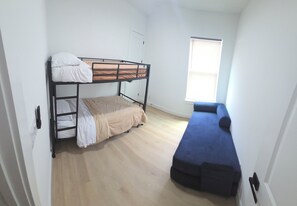 A room with a bunk bed, a single bed, and a window with blinds. - NEW! Houston Retreat, Near Medical District, NRG Stadium & Downtown (Houston)