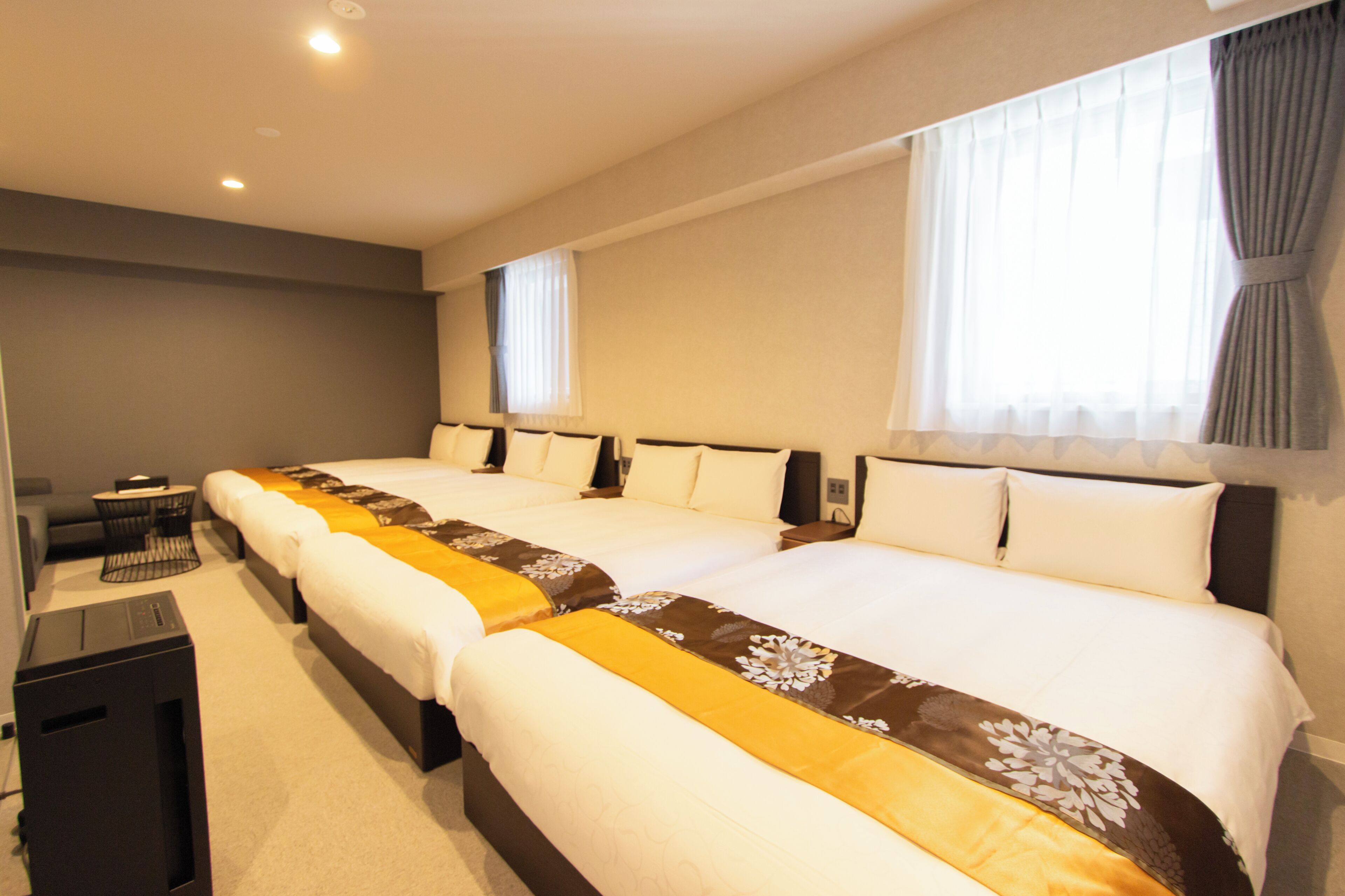 Une chambre d’hôtel avec deux lits, un bureau et une chaise.