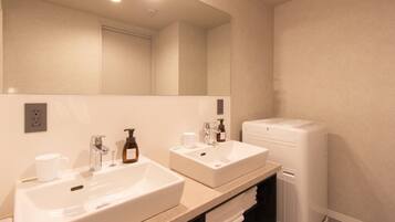 A bathroom with two sinks, a mirror, a towel rack, and a white toilet.