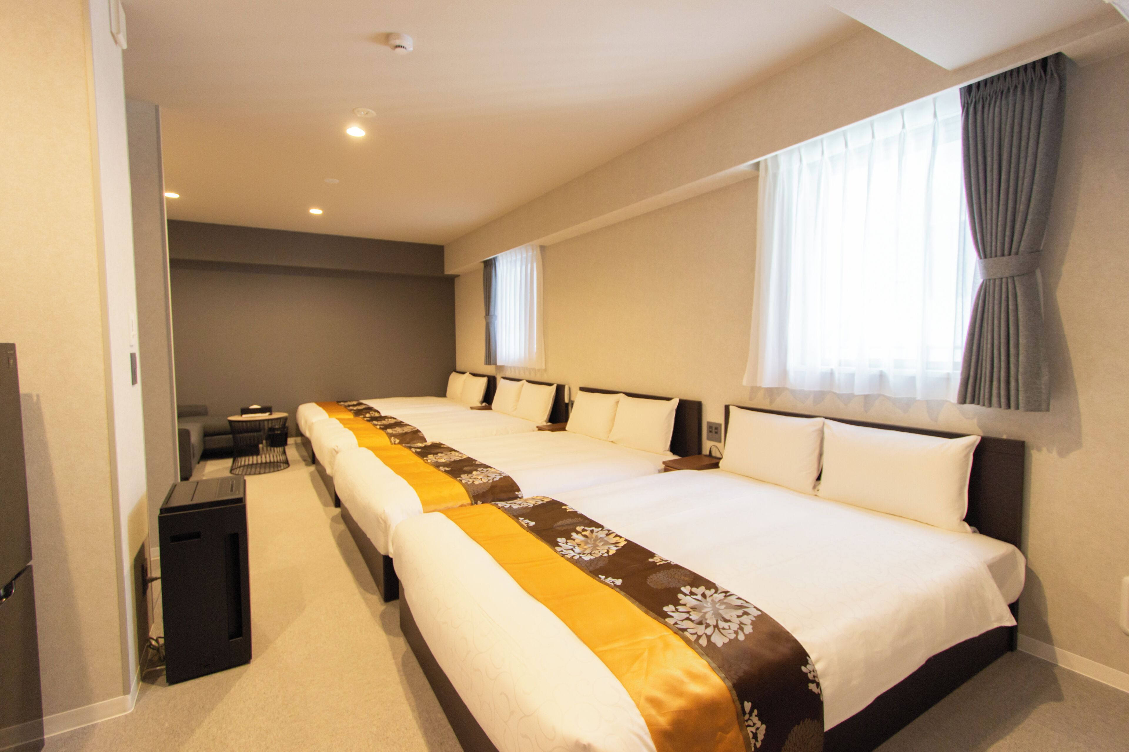 A hotel room with two beds, a desk, and a chair.