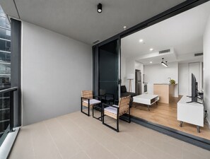 Un intérieur moderne comprenant un coin repas, une cuisine et une grande porte vitrée donnant sur un balcon.