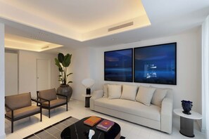 A modern living room with a sofa, chairs, a coffee table, and artwork on the wall. - Villa Baia Serena, Panorama with Private Pool (Massa Lubrense)