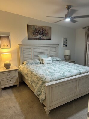 A bedroom with a bed, nightstands, a ceiling fan, and artwork on the walls. - Cozy 2-bedroom condo in gorgeous Wellen Park Golf and Country Club (Venice)
