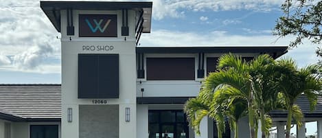 Un edificio moderno con un letrero que dice 'PRO SHOP' y el número '12060' en la fachada.