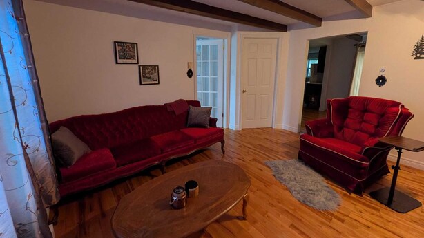 A living room with a red sofa, a red armchair, and a wooden coffee table.