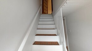 A staircase with white railings and a wooden door at the top.