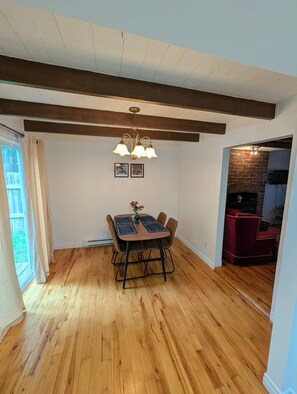 A dining area with a wooden table, chairs, and a chandelier.