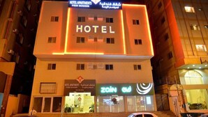 Un edificio de hotel con un letrero llamativo que dice 'HOTEL' y una tienda 'ZAIN' en la planta baja.