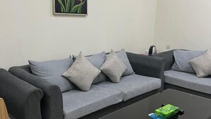 Una sala de estar moderna con dos sofás grises, una mesa de centro negra y un cuadro de tulipanes en la pared.