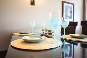 A dining table set with plates, glasses, and a placemat. - KLVR Presents Honua Kai Hokulani 1034 Penthouse (Lahaina)