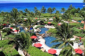 Ein Resort mit Pool, Palmen und Blick auf den Ozean.