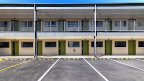A parking garage with multiple levels, marked parking spaces, and fire extinguishers. - Black Nugget Hotel (Moranbah)