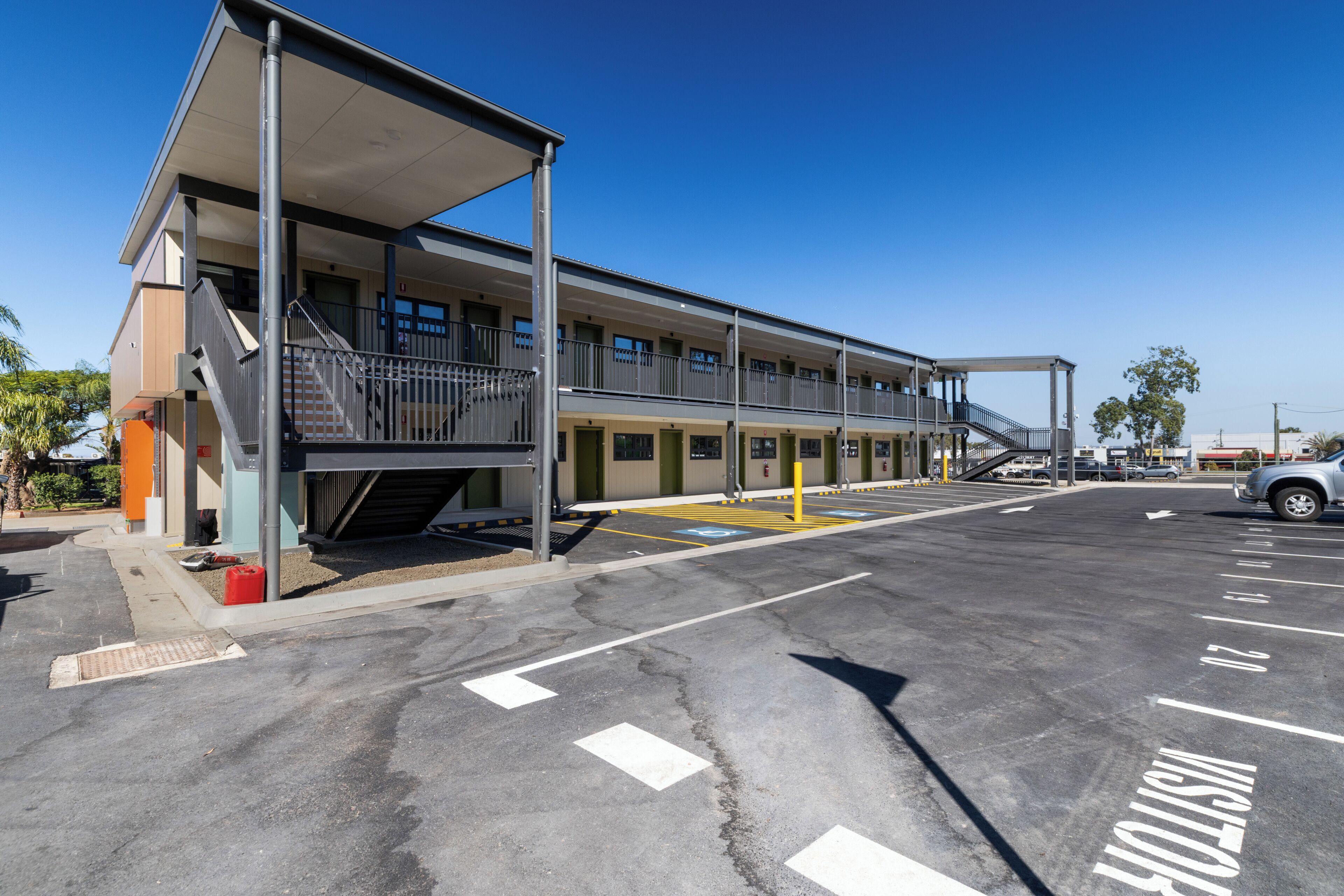 A multi-story building with a covered entrance and a parking lot.
