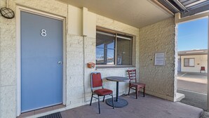 A building entrance with a blue door marked with the number 8, a window with a view, and two chairs outside. - Black Nugget Hotel (Moranbah)