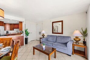 Ein modernes Wohnzimmer mit Sofa, Couchtisch und Essbereich mit Stühlen und Tisch.
