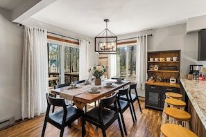 A dining area with a wooden table, black chairs, and a chandelier. - Campfire Nights Start Here. Fireplace, Game Loft & Fall Adventures (Blakeslee)