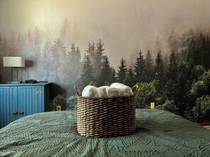 A bedroom with a bed, a blue wardrobe, a wicker basket, and a forest-themed wall mural. - Campfire Nights Start Here. Fireplace, Game Loft & Fall Adventures (Blakeslee)