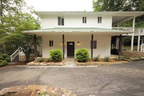A two-story house with a front porch, a staircase leading to a deck, and a well-maintained garden. - Just Heavenly on Smith Lake 4 BR/3BA Pet Friendly (Arley)