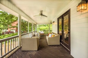 A covered porch with wicker furniture, a ceiling fan, and a view of greenery. - Just Heavenly on Smith Lake 4 BR/3BA Pet Friendly (Arley)