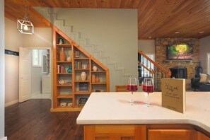 Eine Küche mit einer Holztreppe, einem Steinofen und einem Schild mit der Aufschrift 'Welcome to our Lake House'.