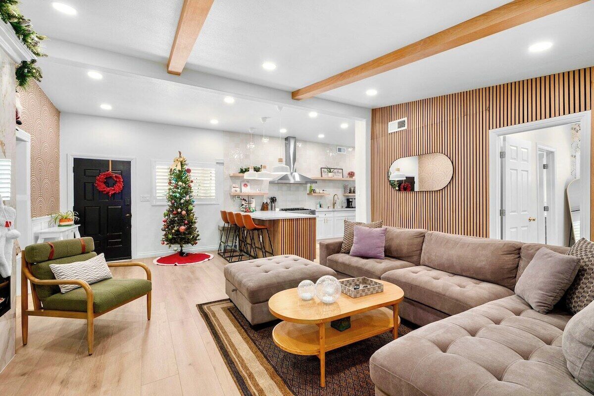 A modern living room with a sofa, armchair, ottoman, and a coffee table.