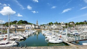 A marina with numerous boats docked, a prominent tower in the background, and buildings along the waterfront. - 4 bedroom nice home in Binic (Binic)
