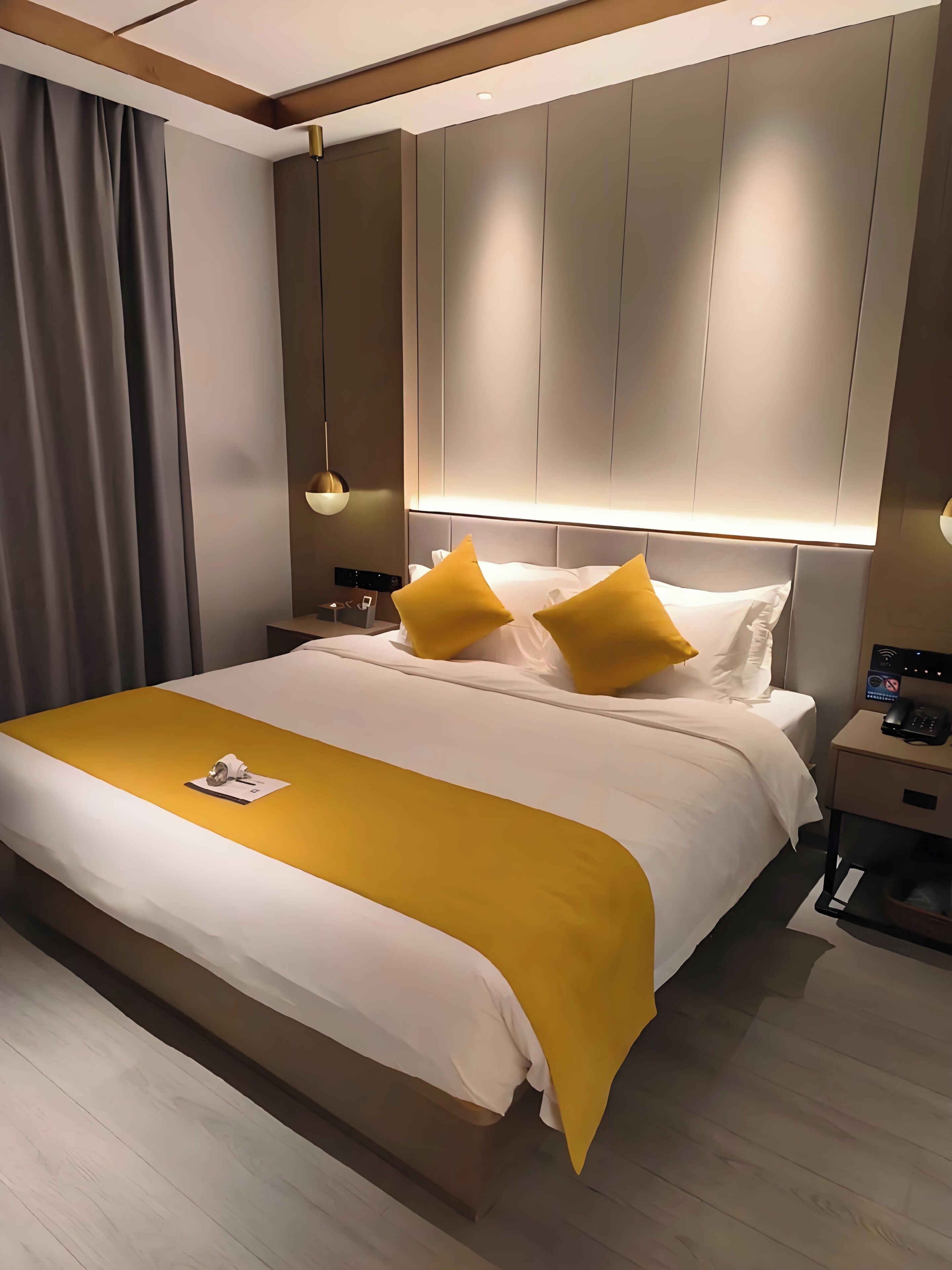 Ein modernes Hotelzimmer mit einem großen Bett, Nachttischen, einem Beistelltisch und einer Wandlampe.