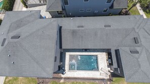 A rooftop swimming pool with a view of the surrounding buildings and a clear sky. - Reunion Haven Villa-1209 (Kissimmee)