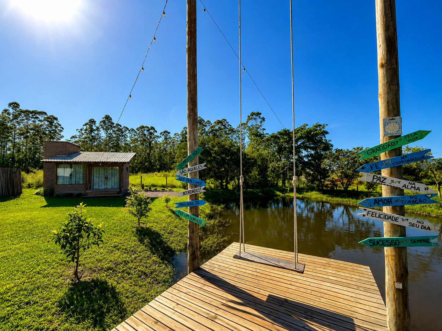 A wooden dock with directional signs, a small building, and a body of water.