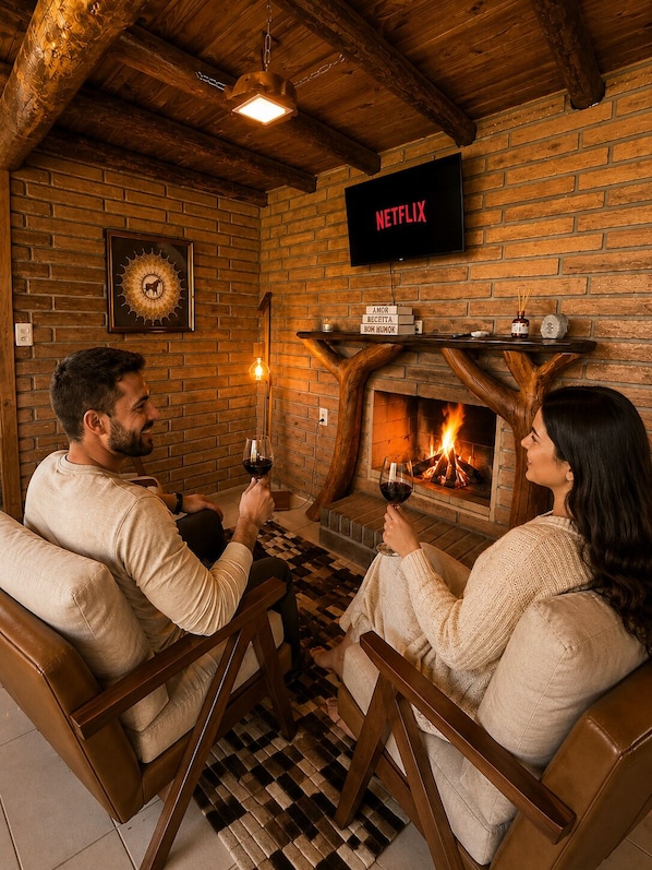 Una habitación acogedora con chimenea, televisor montado en la pared y suelo a cuadros.