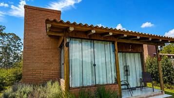 Una casa moderna con fachada de ladrillo, ventanas amplias y un patio cubierto.