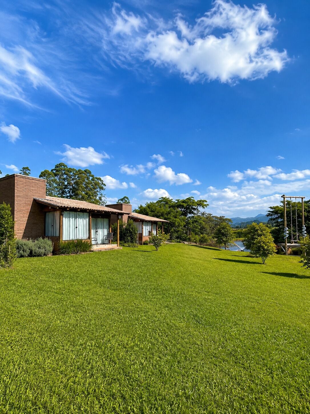 A two-story house with a well-maintained lawn and a clear blue sky.
