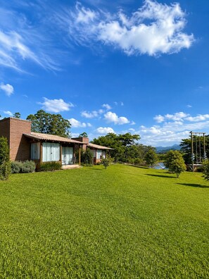 A two-story house with a well-maintained lawn and a clear blue sky.