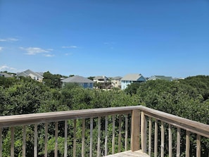 A residential area with houses and a wooden deck. - Spacious Corolla retreat w/ hot tub and rec room! (Corolla)