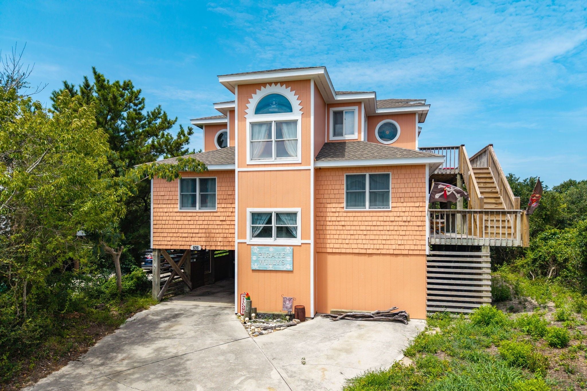 A two-story building with a sign reading 'Pirate Whys' and a wooden deck with a flag.