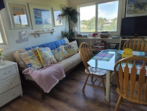 A cozy living room with a sofa, chairs, a glass table, and a television. - Spacious Corolla retreat w/ hot tub and rec room! (Corolla)