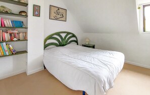A bedroom with a single bed, a bookshelf, a framed picture, and a nightstand with a lamp. - 3 bedroom gorgeous home in Piriac-sur-Mer (Piriac-sur-Mer)