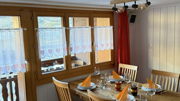 A dining area with a wooden table set for four, surrounded by chairs. - Moritzhaus, (Grächen), 1258 by Interhome (Grächen)