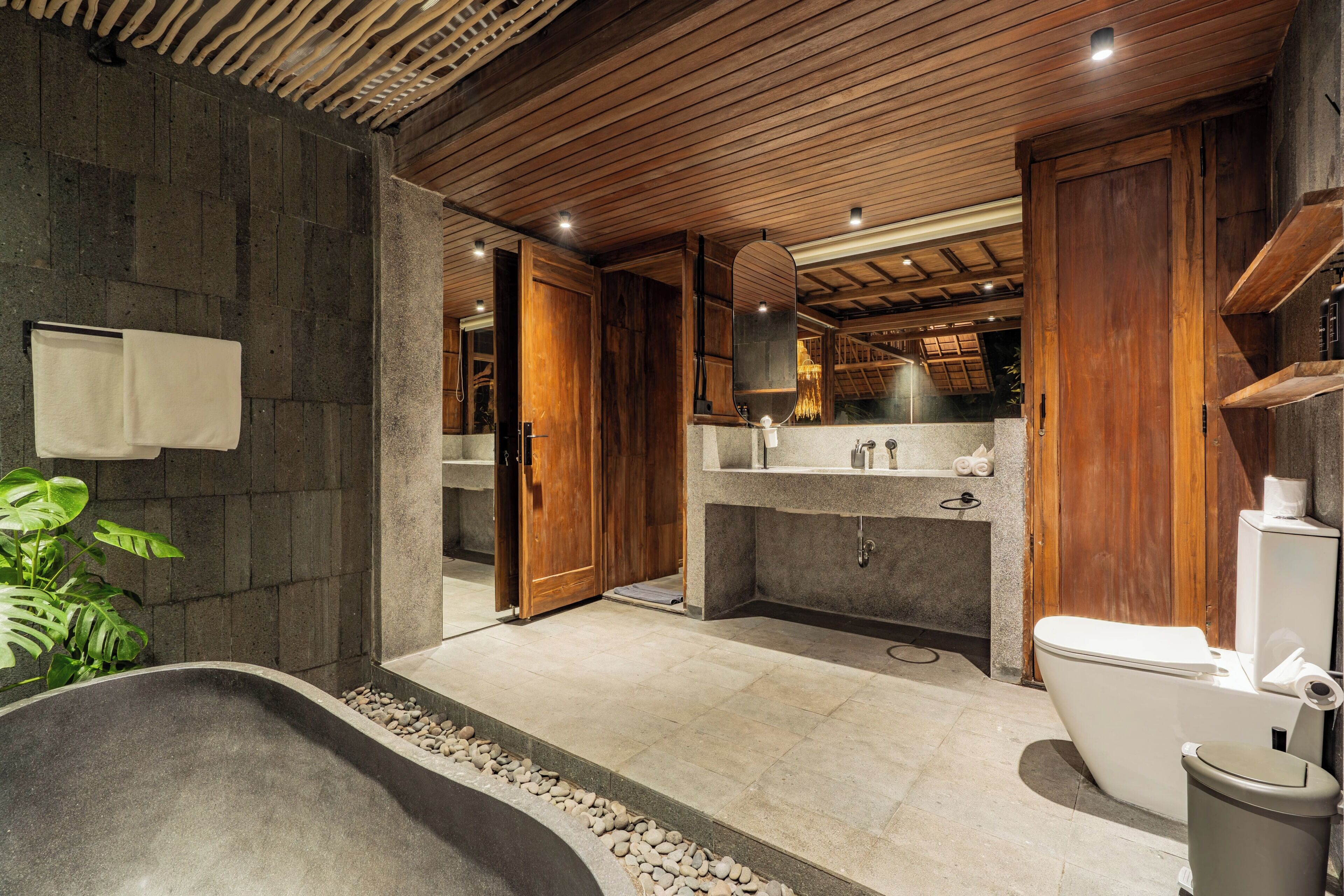 Un baño moderno con una bañera independiente, un inodoro y una zona de lavabo.