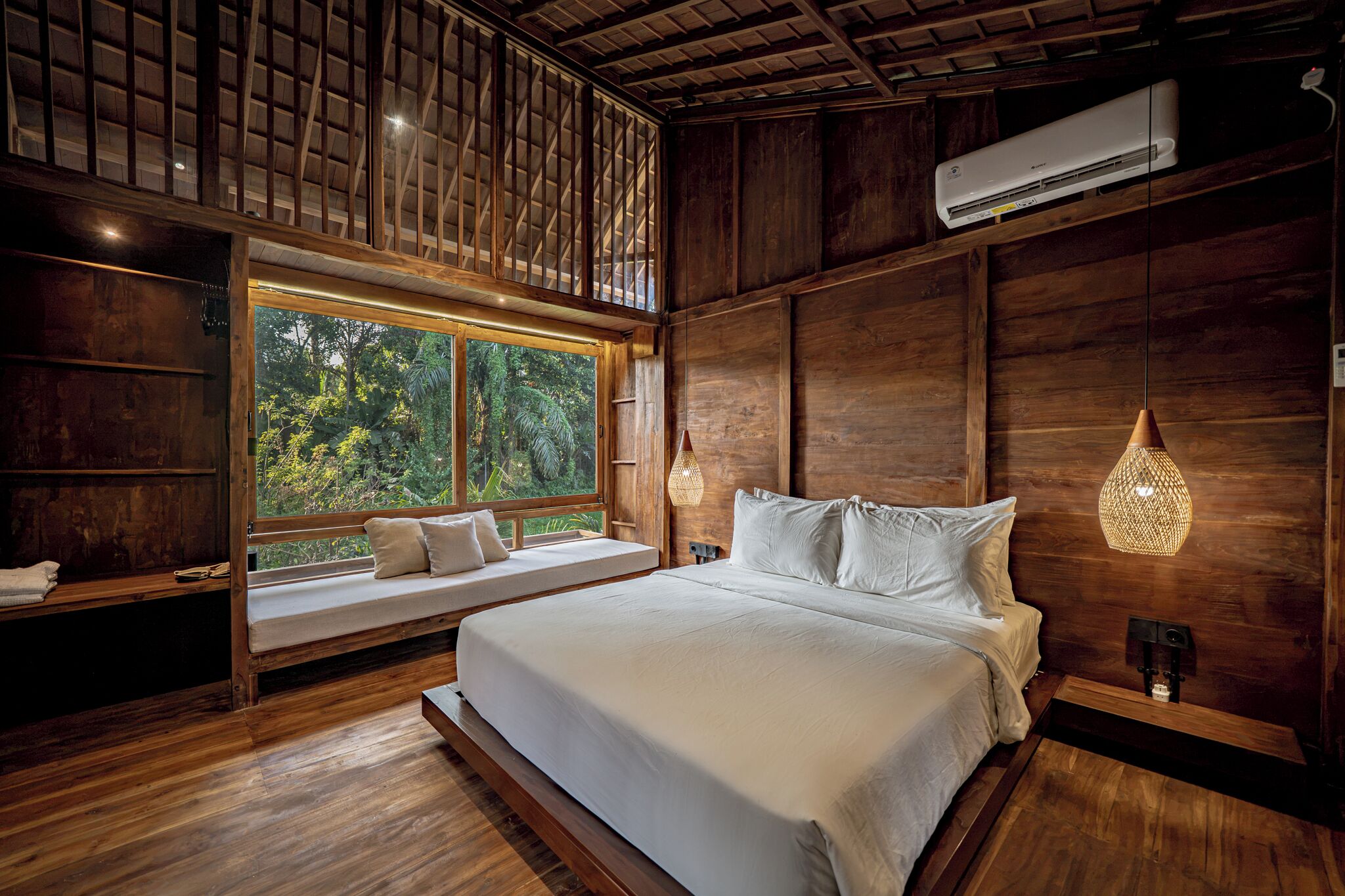 Un dormitorio con una cama grande, un rincón con ventanal y vistas al exterior.