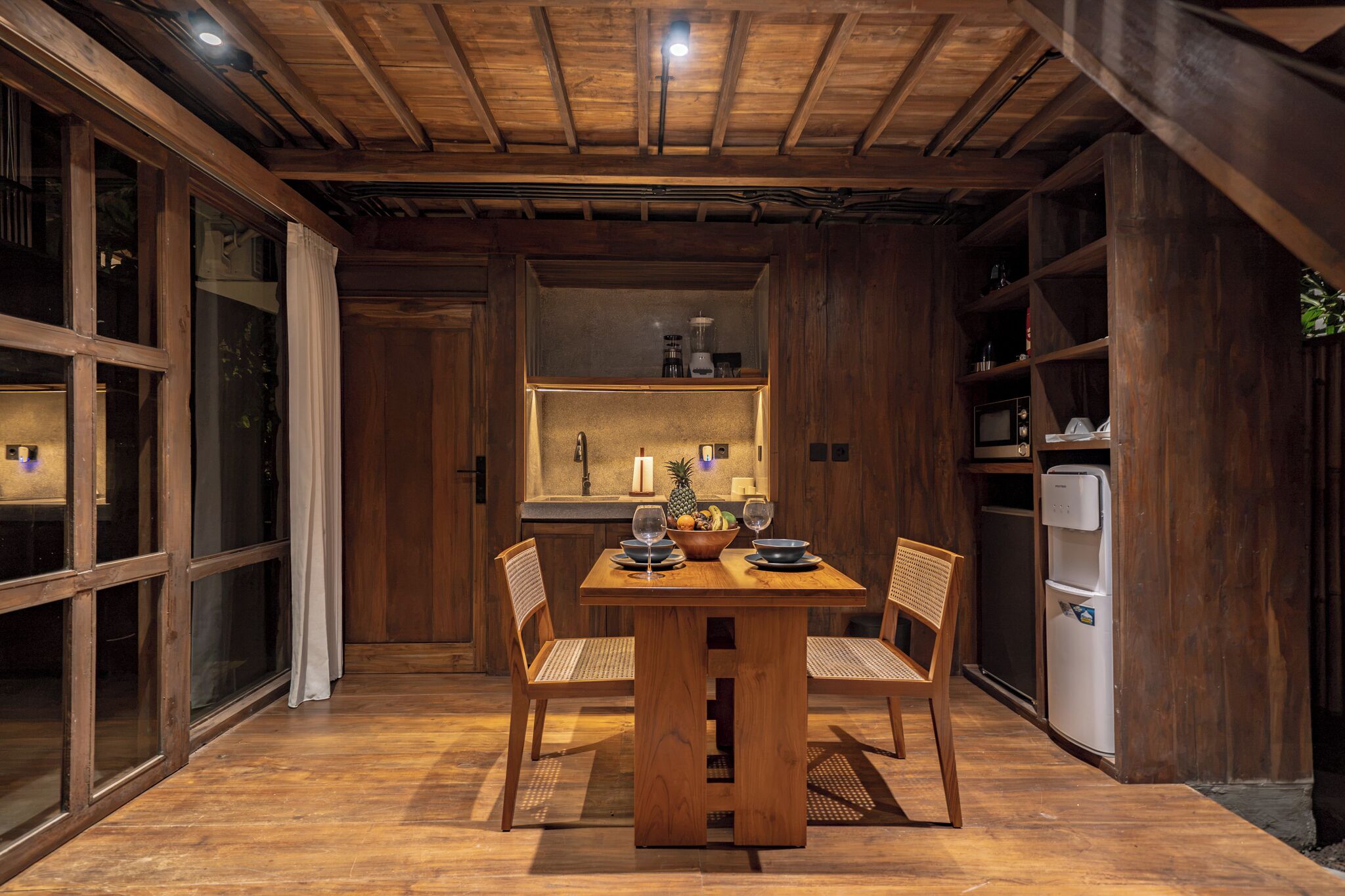 Ein Essbereich mit Holztisch, Stühlen und einer Küche im Hintergrund.