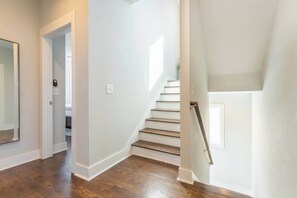 A staircase with wooden steps and white walls, leading to an upper floor. - 4BR East Nashville - Walk to Bars & Restaurants (Nashville)