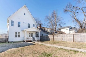 A two-story white house with a covered porch and a fenced backyard. - 4BR East Nashville - Walk to Bars & Restaurants (Nashville)