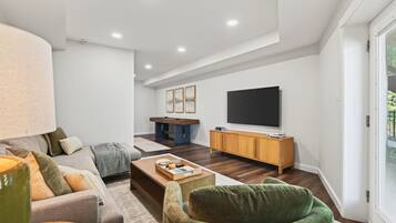 Ein modernes Wohnzimmer mit einer Couch, einem Couchtisch und einem Fernseher.