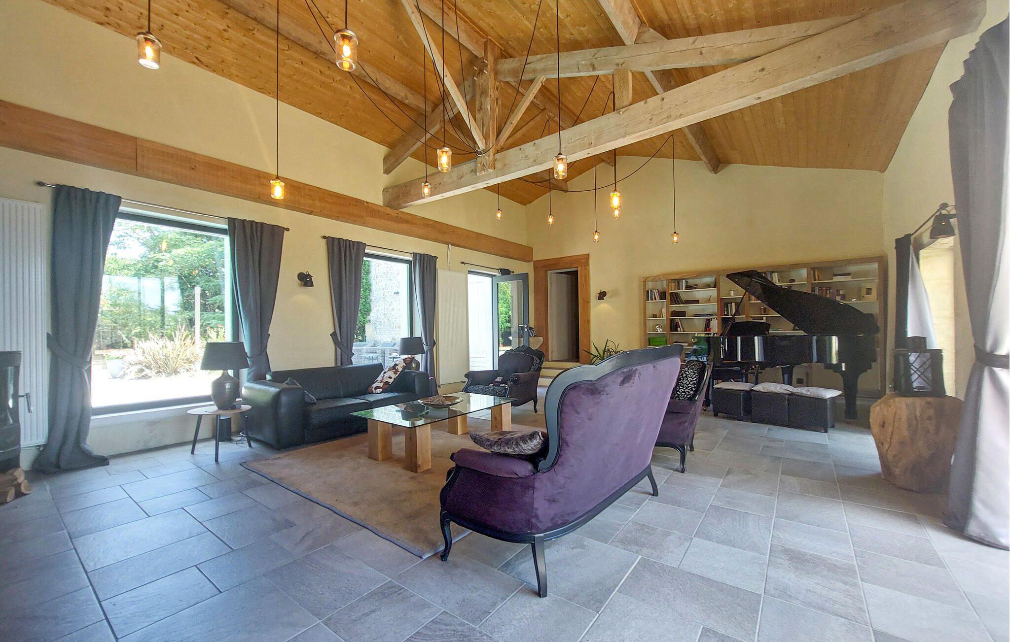 Uma sala de estar espaçosa com um piano, um sofá e uma mesa de centro.