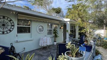 A house with a patio area featuring outdoor furniture and potted plants.