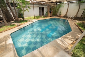 A rectangular swimming pool with a clear blue water surface, surrounded by a concrete deck and a metal ladder. - Casa Helen Your retreat in Cuernavaca (Cuernavaca)