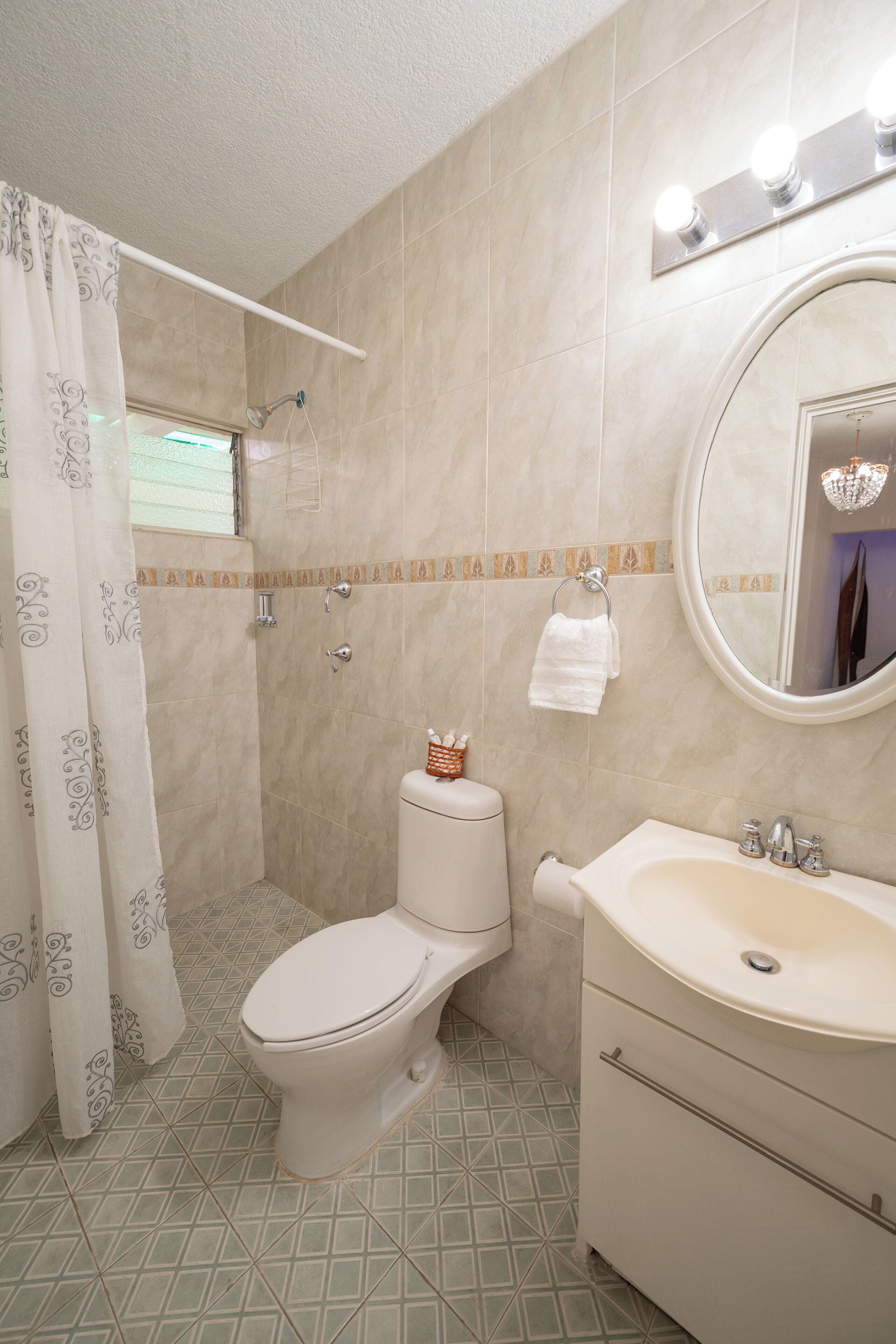 A bathroom with a toilet, sink, and shower.