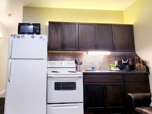 A compact kitchen with dark wooden cabinets, a white refrigerator, a stove, and a microwave. - 1-bedroom/B Resort On Free Shuttle to Ski IN/Out Historic Main Pool Hottub Trail (Park City)