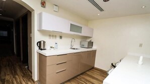 Eine moderne Küche mit weißer Arbeitsplatte, Edelstahlgeräten und Holzböden.